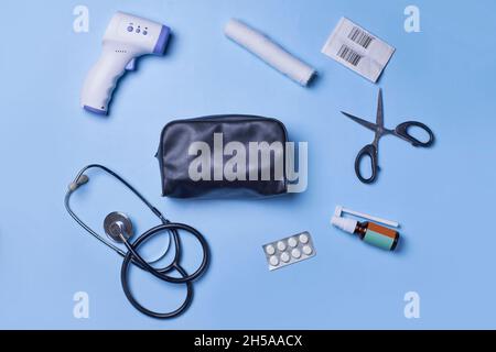 Medical background with various items on blue background. First aid kit package with medial supplies. Infrared thermometer, stethoscope, bandage and Stock Photo