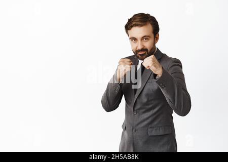 Young businessman in defensive pose afraid of something isolated on ...