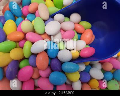 Background of colored chocolate covered with colored sugar, in specialty store, candies or desserts. Backgrounds and textures. Stock Photo