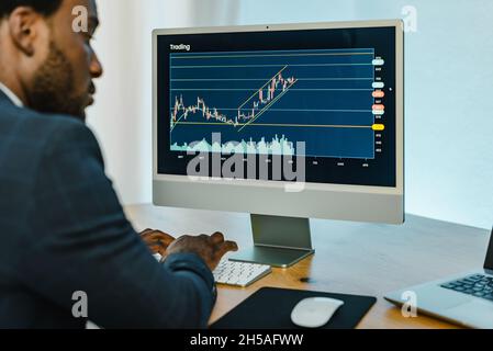 Serious black trader working on computer Stock Photo