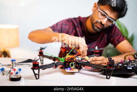 Selective focus on Quadcopter, Engineer student connecting battery to drone at home laboratory - concept of UAV Experiment by testing and assembling Stock Photo