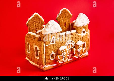 gingerbread house with icing decor on red background. Concept of winter traditional dessert Stock Photo