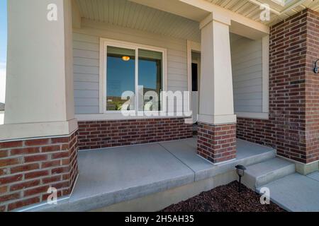Porch exterior of a house with sliding glass window and bricks Stock Photo