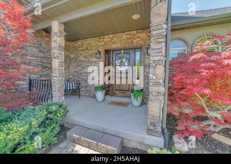 Front door exterior with stone wall and decorated doorstep Stock Photo