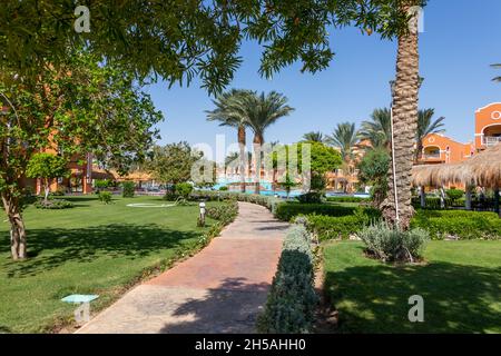 Hurghada, Egypt - September 25 2021: A stone sidewalk through a beautiful Egyptian garden in Hurghada Stock Photo