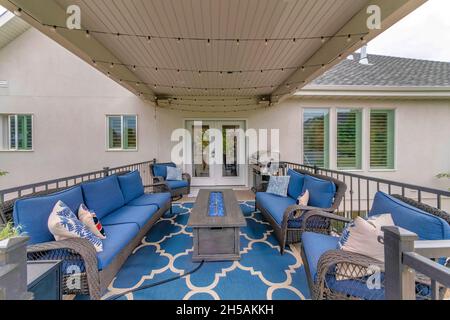 Outdoor deck with string lights, barbecue griller and fire pit table with blue fire glass Stock Photo