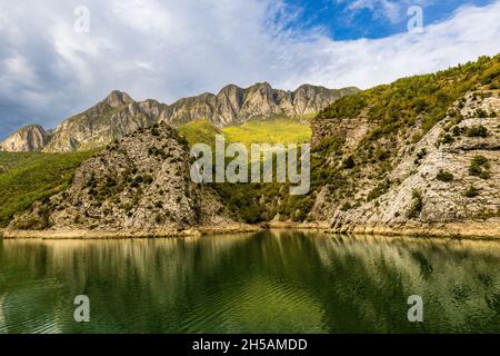lake komani by car ferry is one of worlds best boat trips. sheer cliffs are reflected in emerald water of the narrow lake Stock Photo