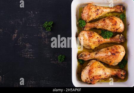 Baked chicken drumsticks on a dark background. Top view, flat lay Stock Photo
