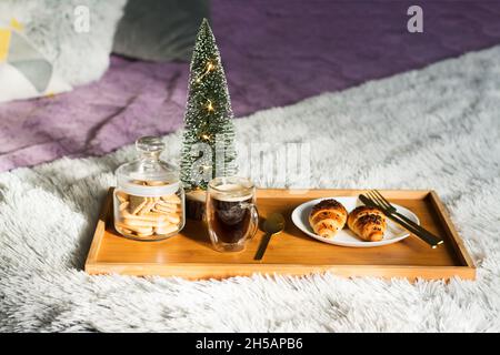 Bed breakfast with coffee cup, croissants and cookies on tray. Christmas morning Stock Photo