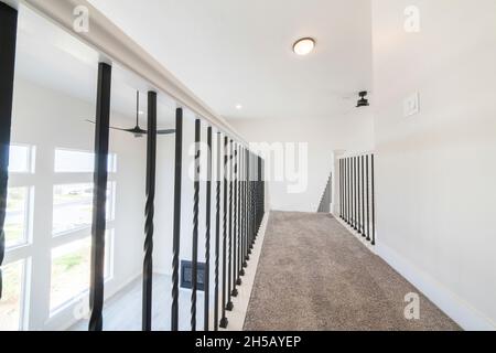 Carpeted flooring on a hallway at the second floor of a house with white siding Stock Photo