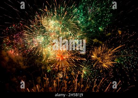 Looking up at fireworks against a night sky Stock Photo