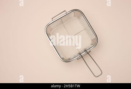 square basket sieve for frying in oil, top view Stock Photo