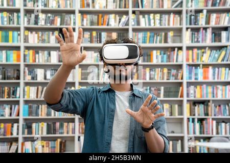 Young indian student using VR simulator for studying in university library Stock Photo