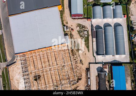 new storehouse building of logistic center under construction. aerial top view from flying drone. Stock Photo