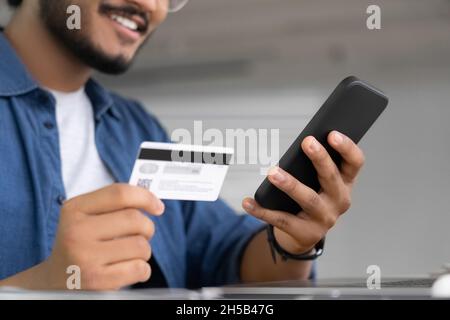 Man using plastic bank card and smartphone for online payment banking service Stock Photo