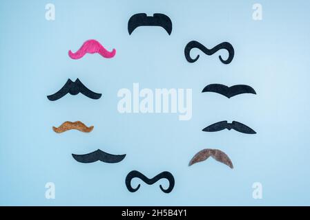 Circle made with funny mustaches and space for text on blue Stock Photo