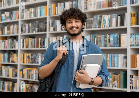 Cheerful male international student at university library or book store Stock Photo