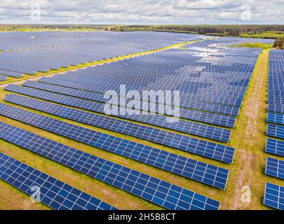 Solar panel produces green, environmentaly friendly energy from the setting sun. Aerial view from drone. Landscape picture of a solar plant that is lo Stock Photo