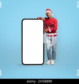 Stylish african american guy in Santa hat with big cellphone Stock Photo