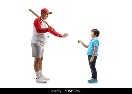 Full length profile shot of a mature man with a baseball bat giving a ball to a boy isolated on white background Stock Photo