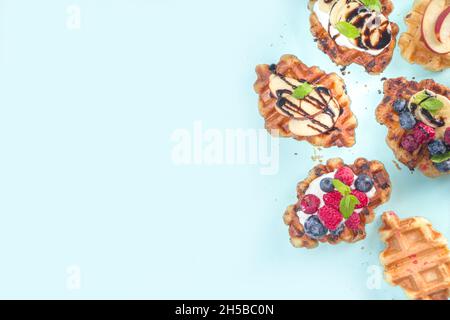 Modern dessert croffle - mixture of croissants and waffles, puff baking waffle iron pan, with berry, fruit cocolate topping Stock Photo