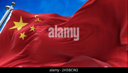 The national flag of People's Republic of China flying in the wind with a clear sky in the background Stock Photo