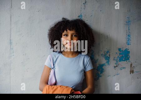 Portrait of teenage girl against wall Stock Photo