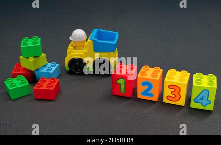Children’s toy truck and building blocks of varying colours and numbers one to four. Stock Photo