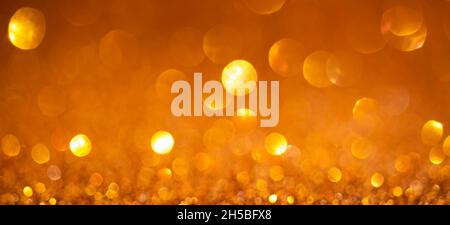 Orange Christmas lights background, banner design. Shiny glowing surface with bokeh, abstract defocused glitter with a sparkles Stock Photo