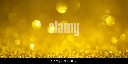 Gold Christmas lights background, banner design. Shiny glowing surface with bokeh, abstract defocused glitter with a sparkles Stock Photo