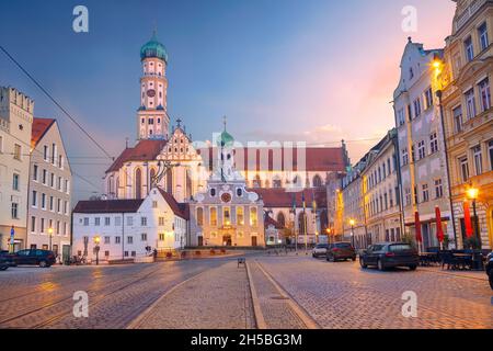 Augsburg, Germany. Cityscape image of old town street of Augsburg, Germany with the Basilica of St. Ulrich and Afra at autumn sunset. Stock Photo