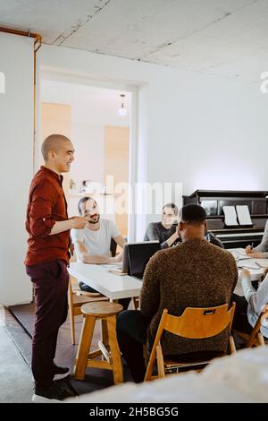 Male hacker presenting business idea during meeting at startup company Stock Photo