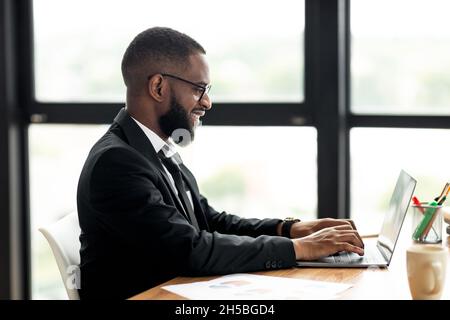 African American man using laptop typing on keyboard Stock Photo