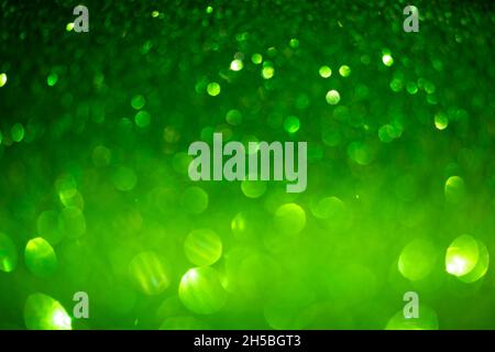Green glittering background. Christmas sparkles, texture with bokeh and shiny lights photo Stock Photo