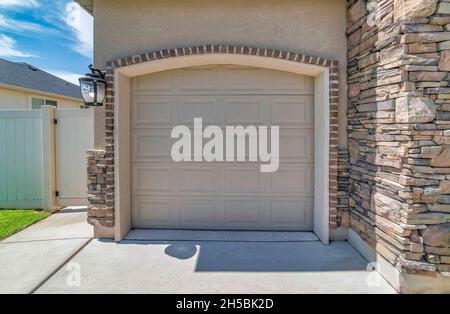 Beige sectional garage door with arched door opening Stock Photo