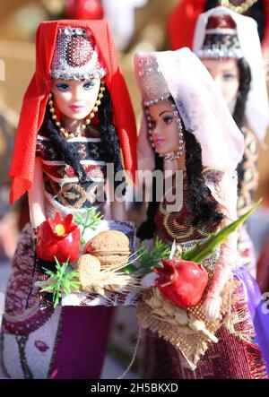 Vertical shot of dolls in national Armenian costumes with toy pomegranates Stock Photo