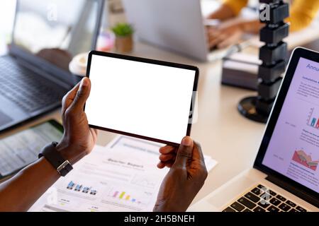 Cropped hands of businessman holding digital tablet with copy space in office Stock Photo