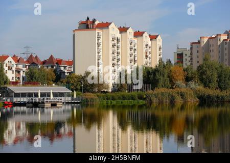 Warsaw, Poland - October 11, 2021: Housing district buildings, in which many families live in the Goclaw housing area, are situated at the lake shore, Stock Photo