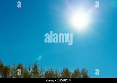 sharply Glowing sun in the blue sky, Autumn and winter season, Stock Photo