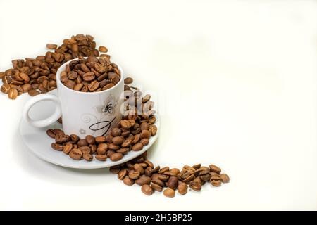 coffee grains in cup and table top on white table Stock Photo