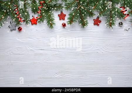 White Christmas background with Christmas tree branches and red berries, winter festive composition with copy space. Top view. Stock Photo