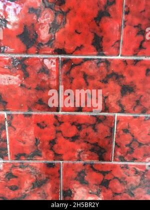 High gloss red tiles with dark marble patterns for modern interior wall design Stock Photo