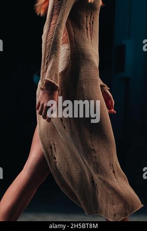 Fashion model n designer stylish beige long dress walking the runway of a fashion show Stock Photo