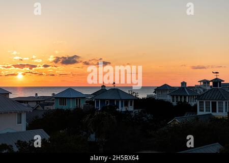 Aerial view on colorful yellow sunset sun with ocean landscape of Gulf of Mexico in Seaside, Florida from rooftop terrace buildings houses cityscape a Stock Photo