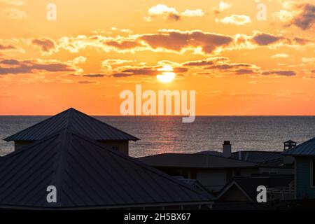 High angle aerial view on colorful yellow sunset ocean landscape horizon of Gulf of Mexico in Seaside, Florida and buildings houses cityscape Stock Photo