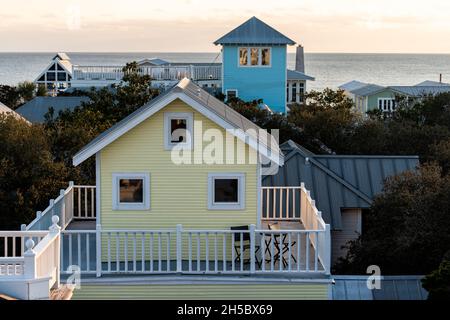High angle aerial view on colorful sunset with ocean landscape of Gulf of Mexico in Seaside, Florida from wooden rooftop buildings yellow houses citys Stock Photo