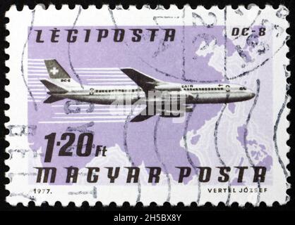 HUNGARY - CIRCA 1977: a stamp printed in Hungary shows plane DC-8, Swissair, Southeast Asia, circa 1977 Stock Photo