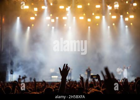 silhouettes of concert crowd in front of stage lights Stock Photo