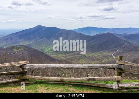 Devil's Knob Overlook with wooden fence and green grass field meadow at Wintergreen resort town village in Blue Ridge mountains in spring springtime Stock Photo