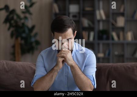 Confused unhappy young man lost in negative thoughts. Stock Photo